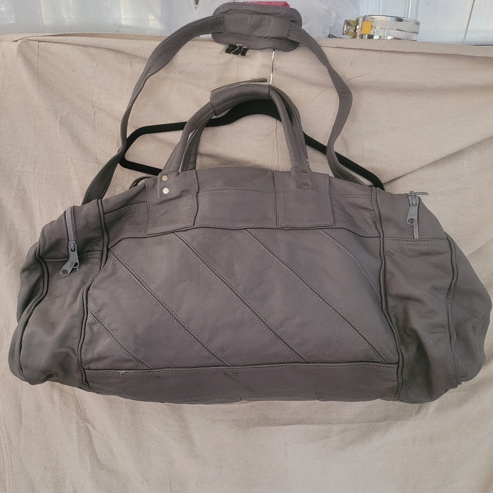 Grey color Leather carry-on bag. Deep side, pockets, lined inner compartment.